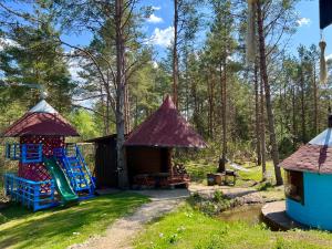 a playground with two huts and a slide at Roosa maja parvesaunaga in Reigi