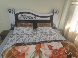 um quarto com uma cama com um edredão preto e branco em Conifers Deluxe Room em Shimla