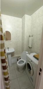 a white bathroom with a toilet and a sink at Циолковского с кодовым замком in Uralsk