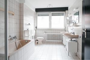 um banheiro com banheira, vaso sanitário e pia em F&E Apartment - groß, freundlich hell em Fellbach