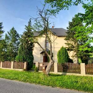 a house with a wooden fence and a tree at ŠulcBurg in Cetenov