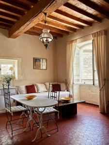 uma sala de estar com uma mesa e um sofá em Appartement aux Arènes em Arles