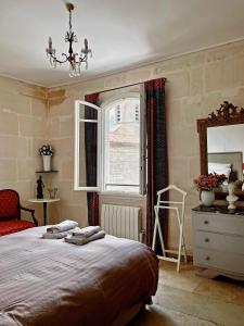 um quarto com uma cama, uma janela e uma cómoda em Appartement aux Arènes em Arles