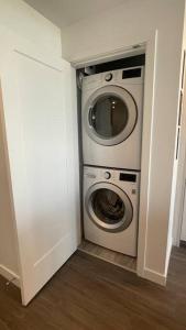 a washer and dryer in a corner of a room at Brand New Starling Luxury Condo with Mountain Views in Burnaby