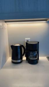 two coffee pots sitting on a shelf in a refrigerator at Brand New Starling Luxury Condo with Mountain Views in Burnaby