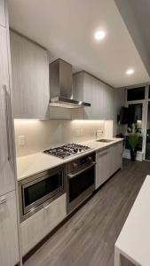 a kitchen with a stove top oven in a kitchen at Brand New Starling Luxury Condo with Mountain Views in Burnaby