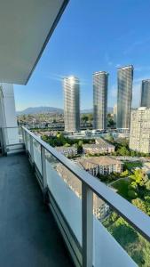 a balcony with a view of a city with tall buildings at Brand New Starling Luxury Condo with Mountain Views in Burnaby