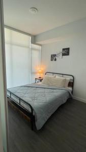 Brand New Starling Luxury Condo with Mountain Views في برنابي: غرفة نوم بسرير كبير في غرفة