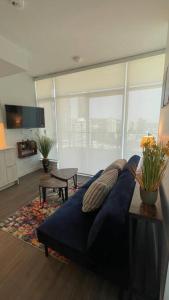 a living room with a blue couch and a large window at Brand New Starling Luxury Condo with Mountain Views in Burnaby