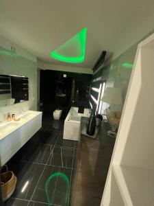 uma casa de banho com 2 lavatórios e luz verde em VistaMare em Marina di Schiavonea