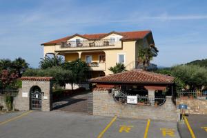 a large house with a gate in a parking lot at Apartmaji Jelena Piran in Piran