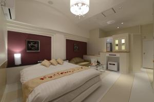 MobaraにあるHOTEL Sweetsの大きなベッドルーム(大型ベッド1台付)、キッチンが備わります。