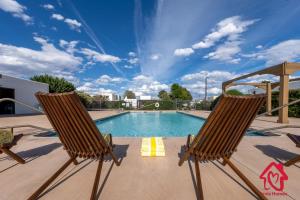 2 sillas sentadas junto a una piscina en The Villa - An Irvie Home, en Albuquerque