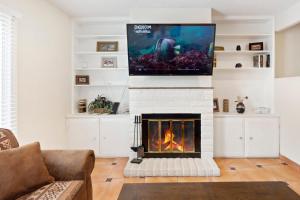 sala de estar con chimenea y TV en la parte superior en The Villa - An Irvie Home, en Albuquerque