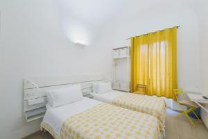 a hotel room with two beds and a desk at Central Savona B&B in Savona