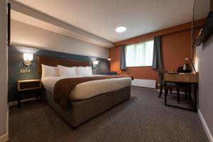 um quarto de hotel com uma cama e uma secretária em Wilmslow Lodge em Wilmslow