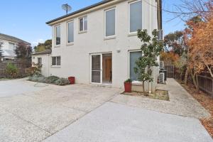 an empty driveway in front of a white house at Retreat on Gairloch I Geelong River Hideaway in Geelong