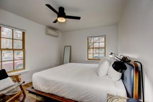 1 dormitorio con 1 cama blanca y ventilador de techo en North End Bungalow 1921 en Boise