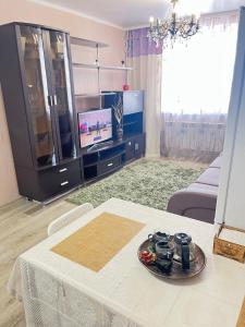 a living room with a table and a tv at Go to in Astana
