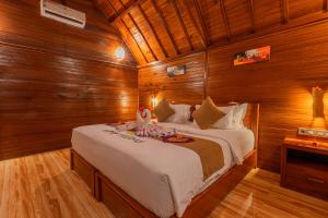 sypialnia z dużym łóżkiem w drewnianym pokoju w obiekcie Bila Penida Resort & Farm w mieście Nusa Penida