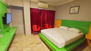 a bedroom with a bed and a television in it at Kita Hotel in Tanjung Pinang 