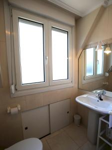 uma casa de banho com 2 janelas e um lavatório em Centenario em San Sebastián