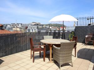 una mesa y sillas en un patio con sombrilla en Centenario, en San Sebastián