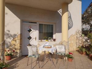 een tafel en 2 stoelen op een patio bij Szilvia apartman in Harkány