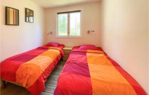 two beds in a room with colorful blankets at 3 Bedroom Stunning Home In Fristad in Fristad