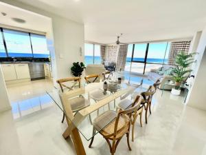 a living room with a glass table and chairs at Seacrest, Surfers Beach Front 15A in Gold Coast
