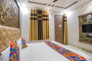 een hotelkamer met een bed en een televisie bij FabExpress Shri Ram Kashi in Prayagraj
