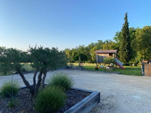 een park met een boom en een speeltuin bij Coulonges in Savignac-sur-Leyze