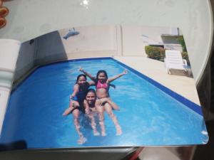 three girls laying in a swimming pool at Aeroporto in Salvador