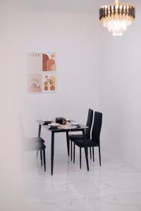 a dining room table with black chairs and a chandelier at D Black Houze Banyuwangi in Banyuwangi +20 photos