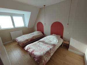 2 Betten in einem Zimmer mit 2 Fenstern in der Unterkunft Maison La Côte in Boulogne-sur-Mer