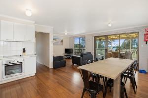 a kitchen and a living room with a table and chairs at Seven on Ophir in Ventnor