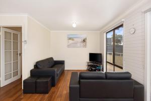 a living room with a couch and a tv at Seven on Ophir in Ventnor