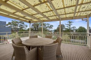a patio with a table and chairs on a deck at Seven on Ophir in Ventnor