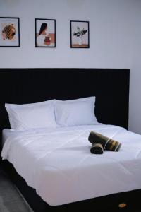 Una cama blanca con dos almohadas encima. en D Black Houze Banyuwangi en Banyuwangi