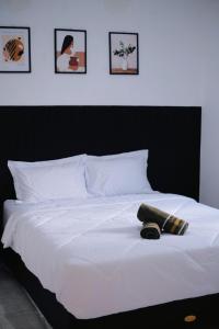 a white bed with two pillows on top of it at D Black Houze Banyuwangi in Banyuwangi