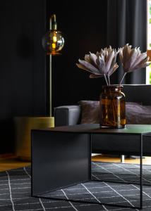 una mesa de café negra con un jarrón de flores. en Oru Villa - Luxury 3 bedroom apartment, en Viljandi