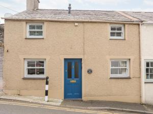 a house with a blue door and two windows at Osborne House in Menai Bridge