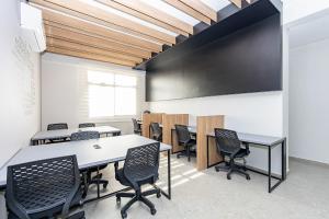 a conference room with tables and chairs and a blackboard at Housi Eco Smart - ECO0601 in Curitiba