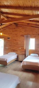1 dormitorio con 2 camas en una cabaña de madera en Yolda Bungalow Cafe, en Kumluca