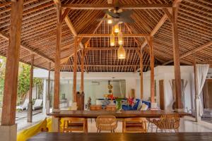a living room with a large wooden table and chairs at Villa Marie Clare in Seminyak