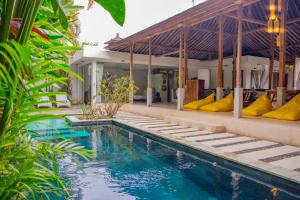 a villa with a swimming pool and a house at Villa Marie Clare in Seminyak
