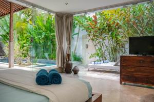 a bedroom with a bed with blue towels on it at Villa Marie Clare in Seminyak