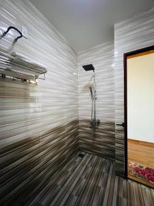 a bathroom with a shower with a wooden floor at Thanh Bình Hotel in Ðoan Xá +17 photos