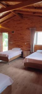 sypialnia z 2 łóżkami i drewnianą ścianą w obiekcie Yolda Bungalow Cafe w mieście Kumluca