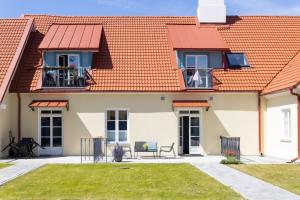 a house with an orange roof and a patio at Brand New Old Town Apartment With Terrace in Haapsalu